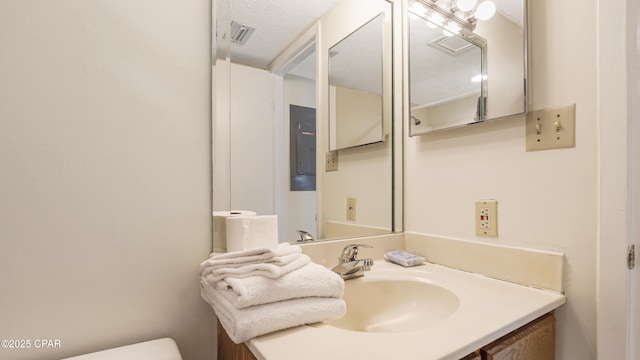 half bathroom featuring toilet, visible vents, and vanity