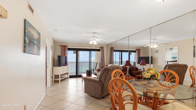 dining room featuring baseboards, a ceiling fan, and light tile patterned floors
