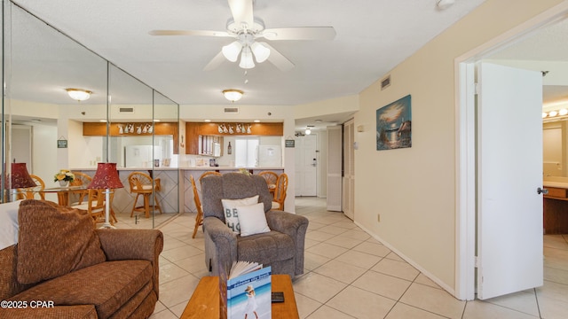 living room with visible vents, a ceiling fan, and light tile patterned floors