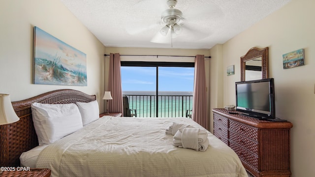 bedroom featuring access to outside, a ceiling fan, and a textured ceiling