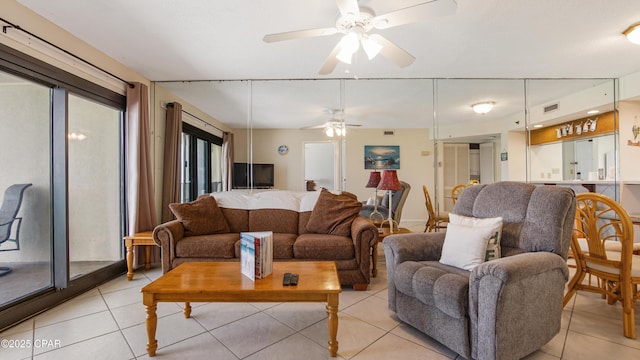 living area with light tile patterned floors, a healthy amount of sunlight, a ceiling fan, and visible vents