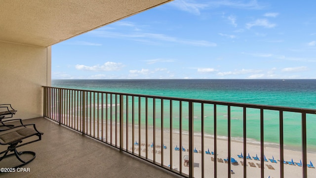 balcony featuring a water view and a beach view