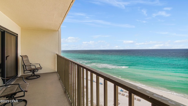 balcony featuring a water view and a view of the beach