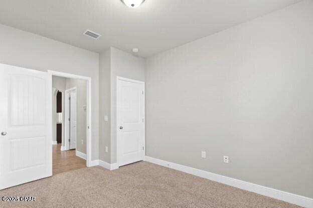 unfurnished bedroom featuring visible vents, carpet flooring, and baseboards