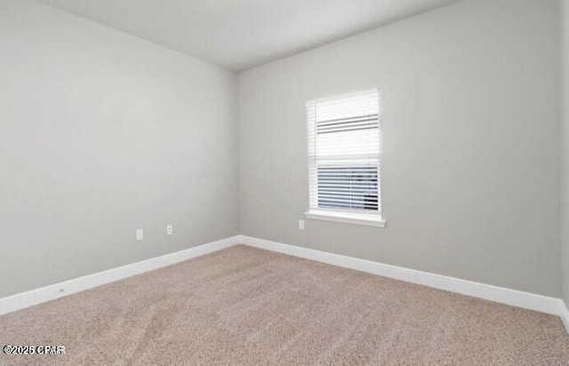 unfurnished room with light colored carpet and baseboards