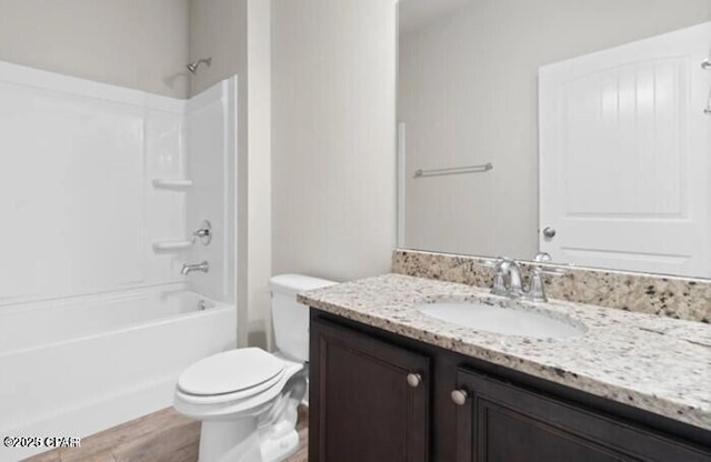 full bathroom with toilet, wood finished floors, shower / bathing tub combination, and vanity