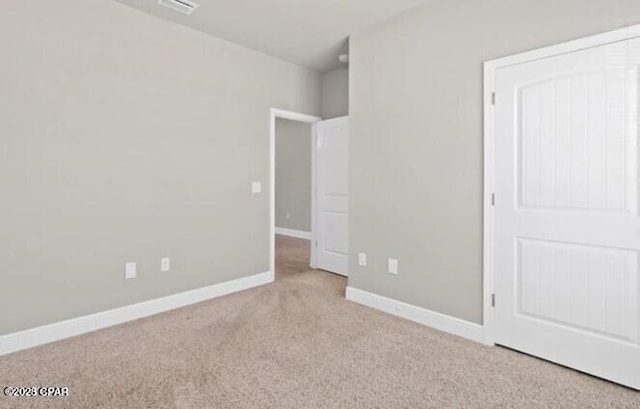 unfurnished bedroom featuring baseboards, visible vents, and carpet
