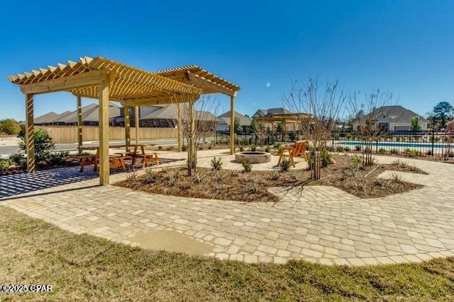 view of patio featuring a community pool, a pergola, fence, and an outdoor fire pit