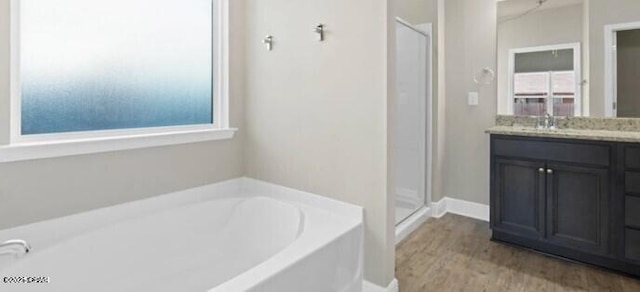 full bath with vanity, a shower stall, a bath, and wood finished floors