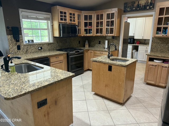 21022 Sweetwater Branch Rd, Fountain, FL 32438 - kitchen featuring stainless steel microwave, range with two ovens, a center island with sink, backsplash, and light stone counters