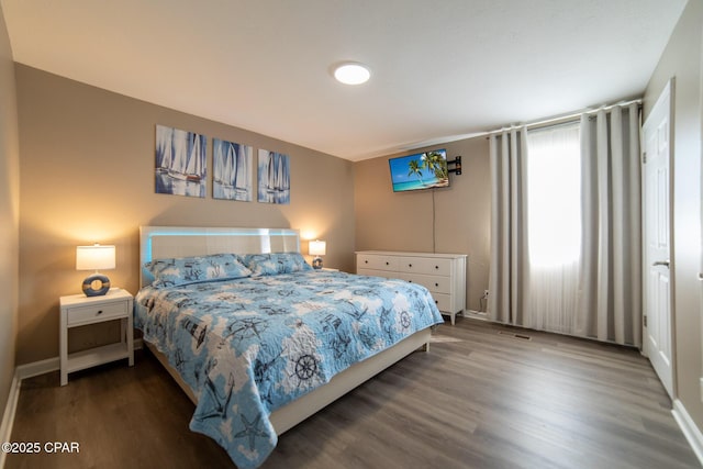 bedroom featuring wood finished floors and baseboards