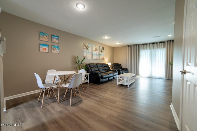 living room featuring wood finished floors, baseboards, and recessed lighting
