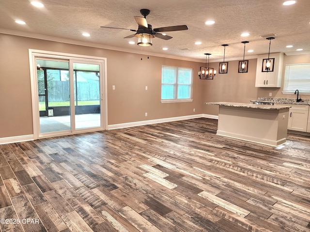 609 E Pine Forest Dr, Lynn Haven, FL 32444 - unfurnished living room featuring ornamental molding, ceiling fan with notable chandelier, recessed lighting, and dark wood-type flooring