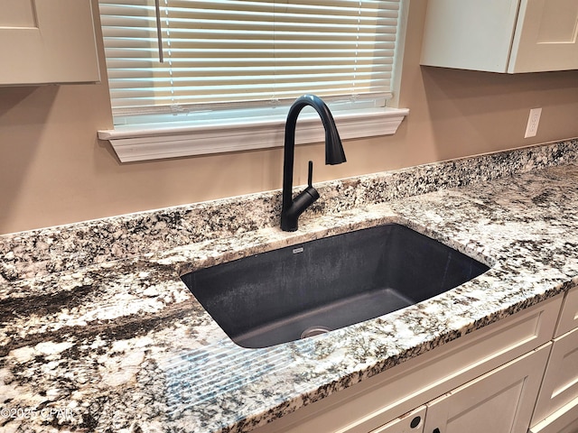 609 E Pine Forest Dr, Lynn Haven, FL 32444 - details featuring a sink, light stone counters, and white cabinetry