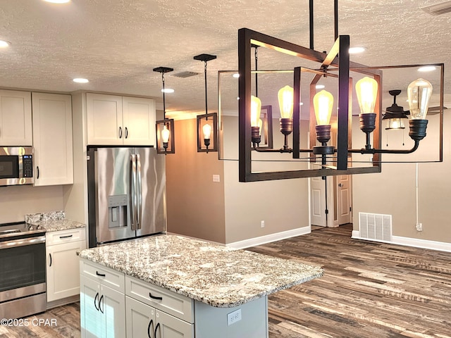 609 E Pine Forest Dr, Lynn Haven, FL 32444 - kitchen with dark wood-style flooring, stainless steel appliances, a textured ceiling, and visible vents