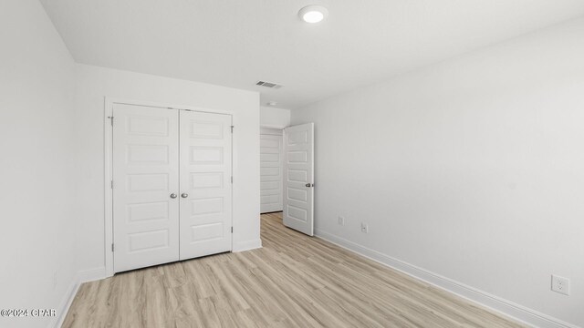 268 Salt Creek Ln, Mexico Beach, FL 32456 - unfurnished bedroom featuring light wood finished floors, baseboards, and a closet