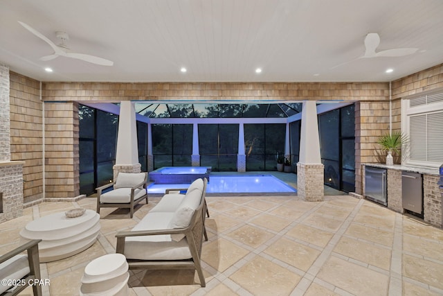 view of patio / terrace featuring a lanai, a ceiling fan, and a jacuzzi