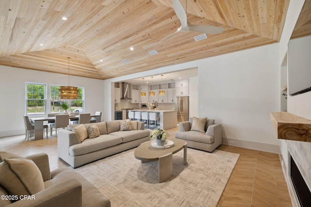 living area with visible vents, baseboards, a notable chandelier, wooden ceiling, and vaulted ceiling