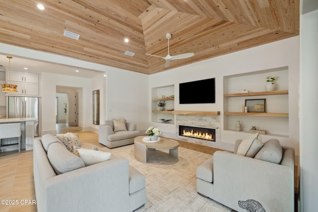 living room featuring recessed lighting, a warm lit fireplace, built in features, and wood ceiling