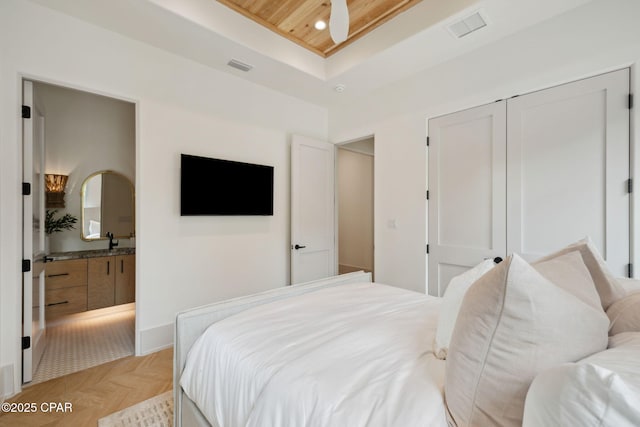 bedroom with visible vents, recessed lighting, a raised ceiling, and a sink
