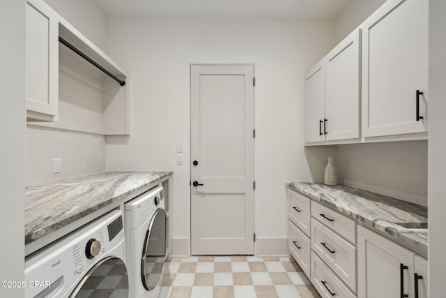 washroom featuring cabinet space, baseboards, washing machine and dryer, and light floors