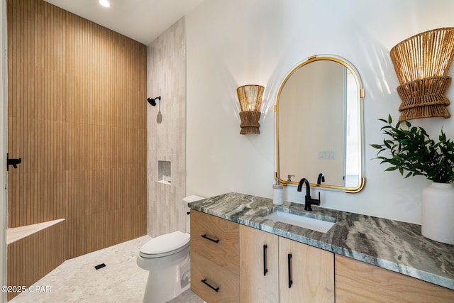 bathroom with recessed lighting, vanity, toilet, and tiled shower