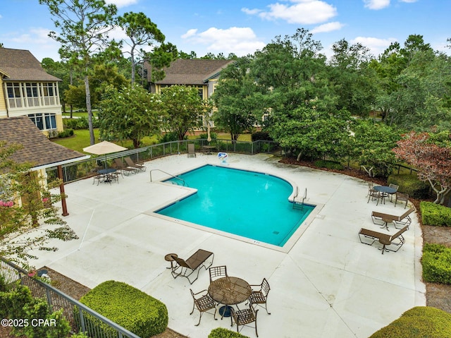 community pool with fence and a patio area