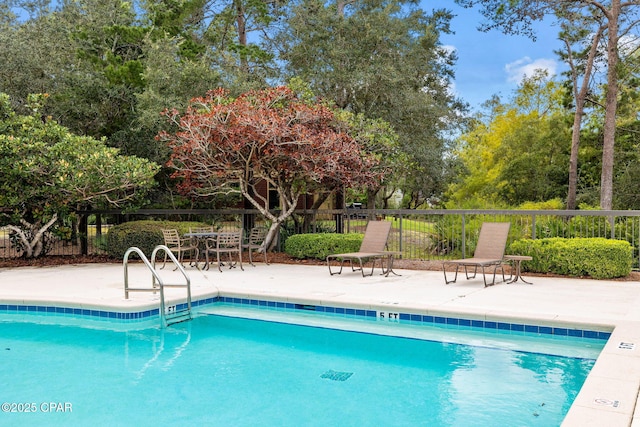 community pool with fence and a patio area