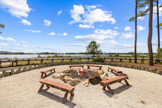 exterior space with a water view and a fire pit