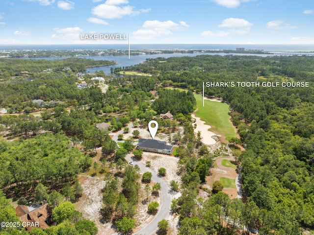 bird's eye view featuring a water view, golf course view, and a wooded view