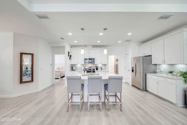 8738 Sand Dollar Dr, Panama City Beach, FL 32413 - kitchen with stainless steel appliances, light wood-type flooring, and decorative backsplash