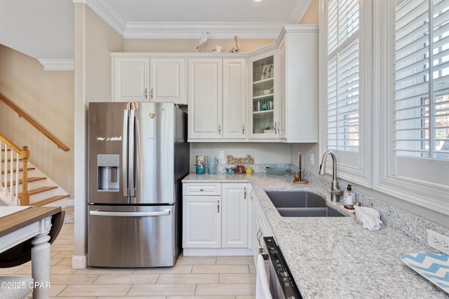 kitchen featuring glass insert cabinets, white cabinetry, stainless steel fridge, and a sink