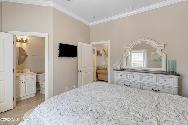 bedroom with ensuite bathroom, ornamental molding, and light wood-style floors