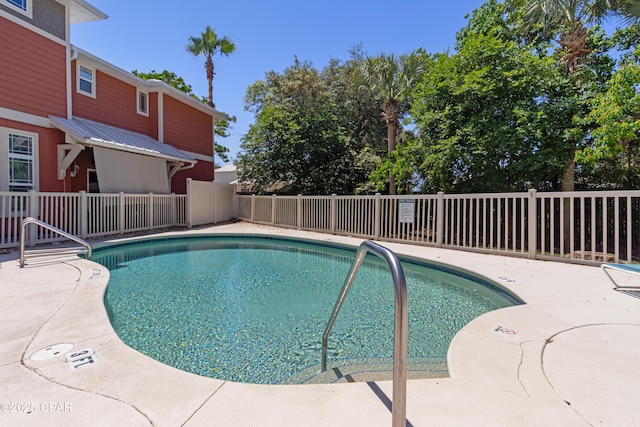 community pool with a patio and fence