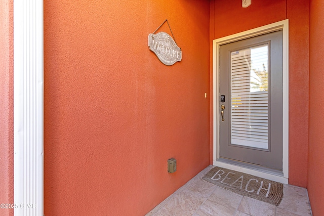 property entrance with stucco siding