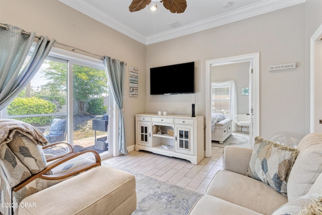 living area featuring crown molding, baseboards, a ceiling fan, and a healthy amount of sunlight