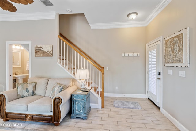 entrance foyer with baseboards, visible vents, crown molding, wood finish floors, and stairway