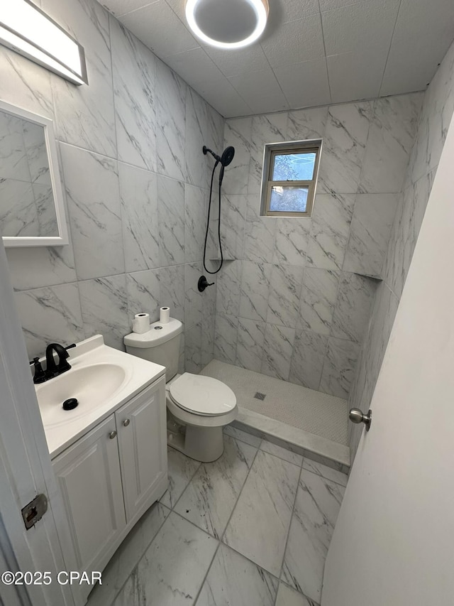 3733 Benbow St, Panama City Beach, FL 32408 - bathroom with a stall shower, vanity, marble finish floors, toilet, and tile walls