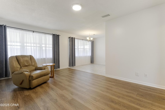 3947 Verona Cir, Panama City, FL 32405 - sitting room with visible vents, light wood-style flooring, baseboards, and an inviting chandelier