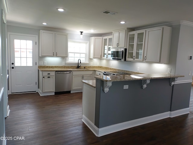 2525 E 40th Ct, Panama City, FL 32405 - kitchen featuring a kitchen breakfast bar, visible vents, appliances with stainless steel finishes, a sink, and a peninsula