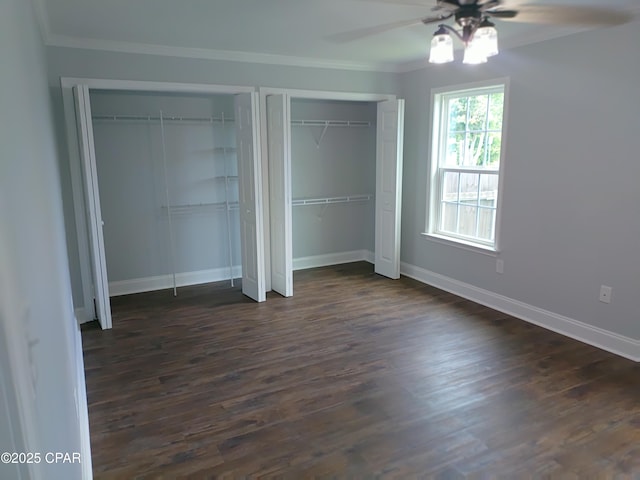 2525 E 40th Ct, Panama City, FL 32405 - unfurnished bedroom featuring a ceiling fan, crown molding, baseboards, multiple closets, and dark wood-type flooring