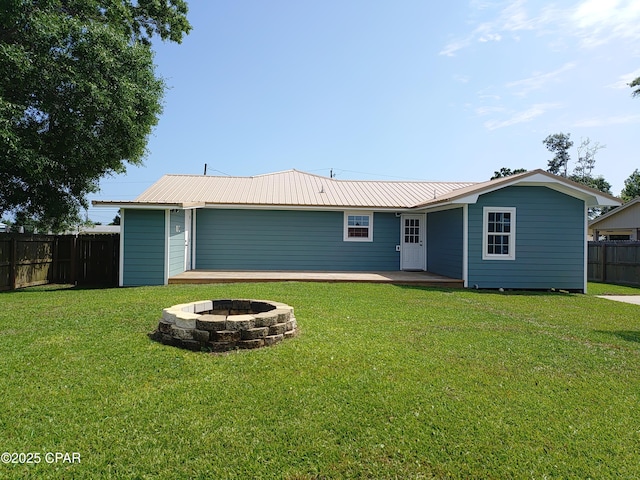 2525 E 40th Ct, Panama City, FL 32405 - rear view of property featuring a lawn, a fire pit, fence, and metal roof
