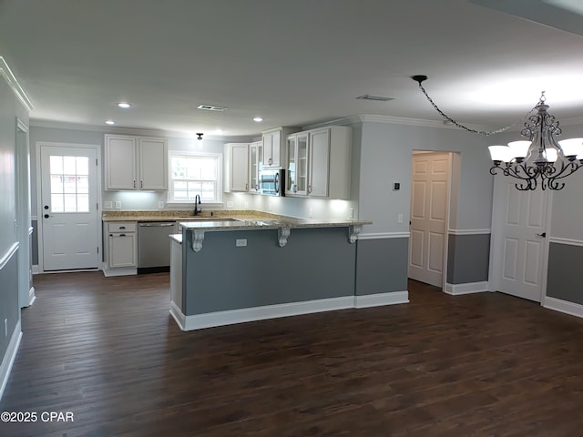 2525 E 40th Ct, Panama City, FL 32405 - kitchen featuring visible vents, ornamental molding, dark wood-style flooring, a peninsula, and stainless steel appliances
