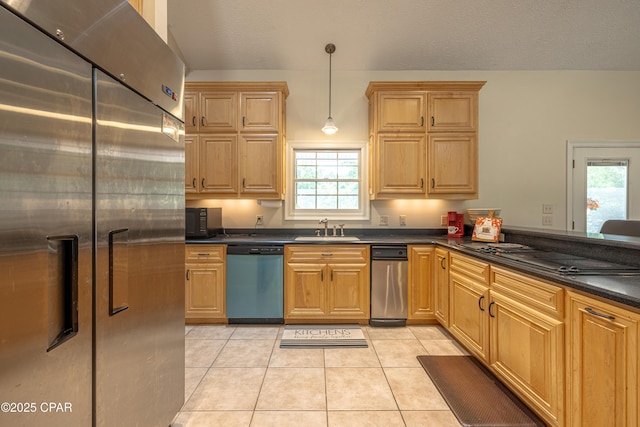 kitchen with dark countertops, hanging light fixtures, a sink, light tile patterned floors, and black appliances