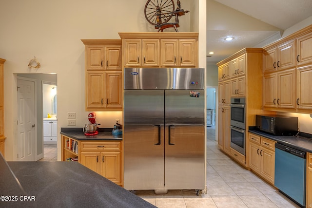 kitchen with stainless steel appliances, dark countertops, vaulted ceiling, and light tile patterned floors