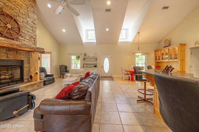 living area with light tile patterned flooring, high vaulted ceiling, visible vents, and ceiling fan