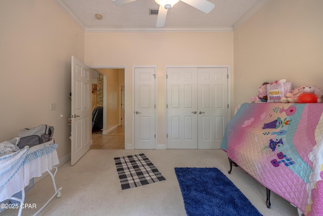 bedroom with carpet, a ceiling fan, baseboards, ornamental molding, and a closet
