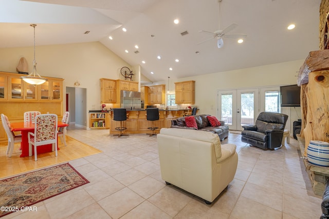 living area with high vaulted ceiling, a ceiling fan, light tile patterned flooring, and visible vents