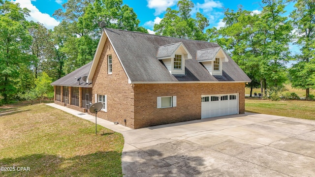 view of side of home with a yard, brick siding, concrete driveway, and a sunroom