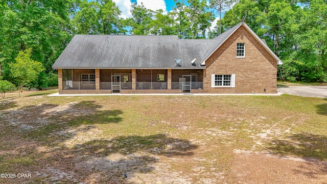 back of house featuring a lawn and a sunroom